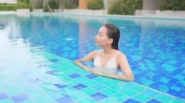 Otelde yüzme havuzunda dinlenen Asyalı güzel bir kadının görüntüsü.