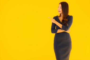 İzole edilmiş sarı arka planda hareketli güzel Asyalı kadın portresi.