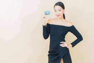 Güzel bir Asyalı kadının portresi. Renkli kredi kartıyla gülüyor.