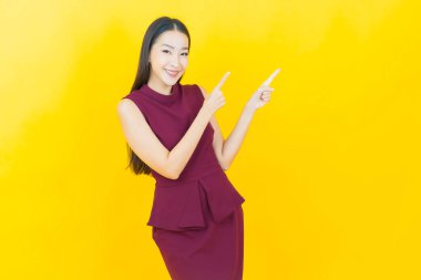 Portre güzel Asyalı kadın gülümsüyor. Renkli arka planda hareket var.