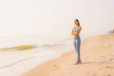Portre sporu genç Asyalı kadın egzersiz hazırlıyor ya da sağlık için okyanusta koşuyor.