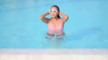 Otelde yüzme havuzunda dinlenen Asyalı güzel bir kadının görüntüsü.
