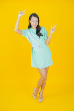 Portre güzel Asyalı kadın gülümsüyor. Renkli arka planda hareket var.