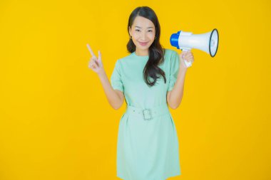 Güzel bir Asyalı kadının portresi. Arka planda megafonla gülümsüyor.