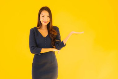 İzole edilmiş sarı arka planda hareketli güzel Asyalı kadın portresi.