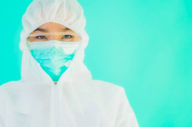 Güzel, genç Asyalı doktor kadın portre. Koronavirüsten ya da mavi arka planda kovid19 'dan korunmak için ppe ya da kişisel koruyucu ekipman takıyor.