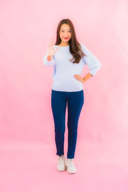 Portrait beautiful young asian woman smile with action on pink isolated background