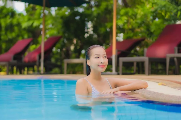 아름다운 여성이 휴가를 보내기 리조트 수영장에서 느긋하게 미소짓는 여가를 즐긴다 — 스톡 사진