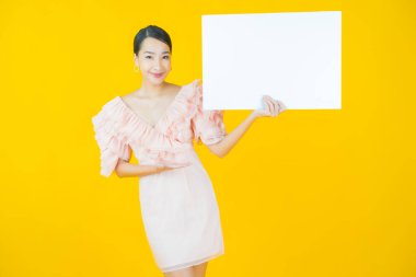 Renkli arka planda boş beyaz ilan panosu olan güzel Asyalı kadın portresi