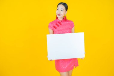 Renkli arka planda boş beyaz ilan panosu olan güzel Asyalı kadın portresi