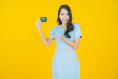 Güzel bir Asyalı kadının portresi. Renkli kredi kartıyla gülüyor.