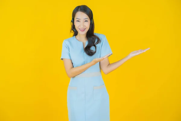 黄色の色の背景にコールセンターカスタマーケアサービスセンターと肖像美しい若いアジアの女性 — ストック写真