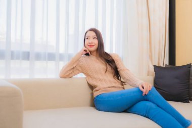 Güzel bir Asyalı kadın portresi rahatla. Gülümse. Yatak odasının iç dekorasyonunda mutlu ol.