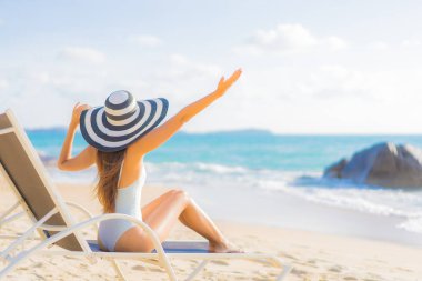 Güzel bir Asyalı kadının portresi. Rahatlayın. Plaj okyanusunda tatil yaparken gülümseyin.