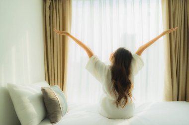 Genç Asyalı mutlu gülümseme. Yatak odasında iç tarafta rahatla.