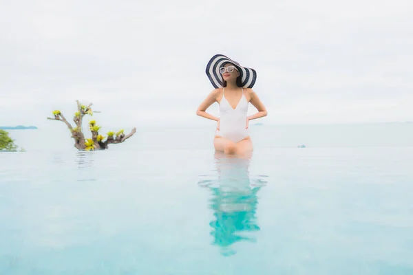 亚洲年轻貌美的女子在度假胜地的室外游泳池边微笑 放松和休闲 — 图库照片