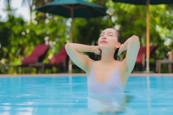 아름다운 여성이 휴가를 보내기 리조트 수영장에서 느긋하게 미소짓는 여가를 즐긴다 — 스톡 사진