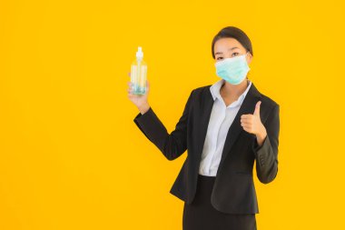 Güzel bir iş kadını portresi. Maske takıyor. Korunmak için alkol jeli kullanıyor.
