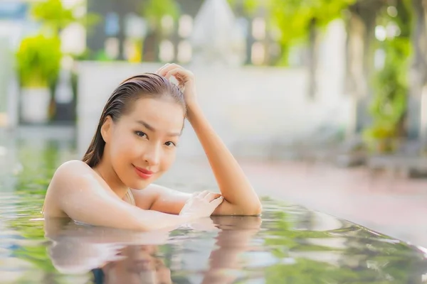 美丽动人的年轻亚洲女人度假时 在酒店度假胜地的室外游泳池边放松微笑 — 图库照片