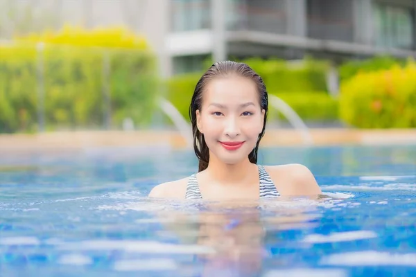 ポートレート美しい若いアジアの女性は休暇旅行でホテルのリゾートで屋外スイミングプールの周りの笑顔のレジャーをリラックス — ストック写真