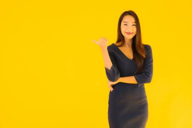 İzole edilmiş sarı arka planda hareketli güzel Asyalı kadın portresi.