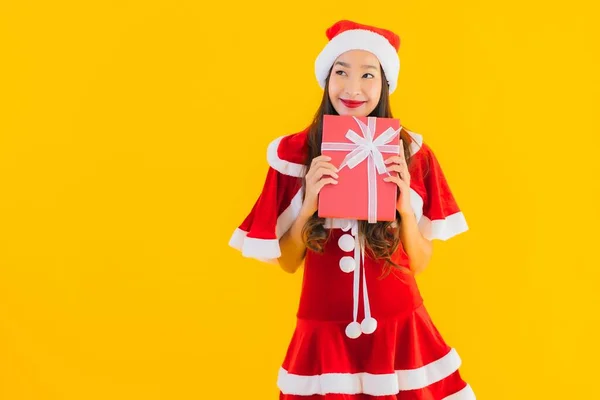 肖像画美しい若いアジアのクリスマス服と帽子の笑顔幸せとともに赤ギフトボックス上の黄色隔離された背景 — ストック写真