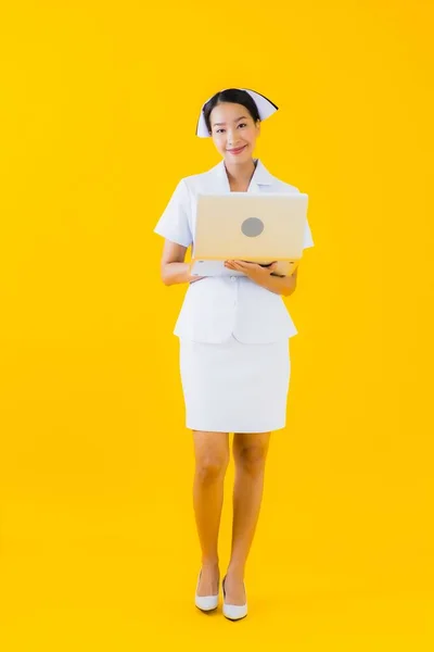 Sarı Izole Edilmiş Dizüstü Bilgisayarlı Güzel Asyalı Kadın Hemşire Portresi — Stok fotoğraf