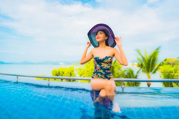 아름다운 여성이 휴가를 즐기기 바다를 바라보며 수영장에서 미소짓고 — 스톡 사진