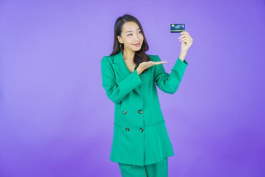 Güzel bir Asyalı kadının portresi. Renkli kredi kartıyla gülüyor.