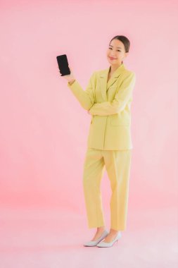 Güzel Asyalı iş kadını portresi. Arka planda kahve fincanı ve akıllı cep telefonu kullanıyor.