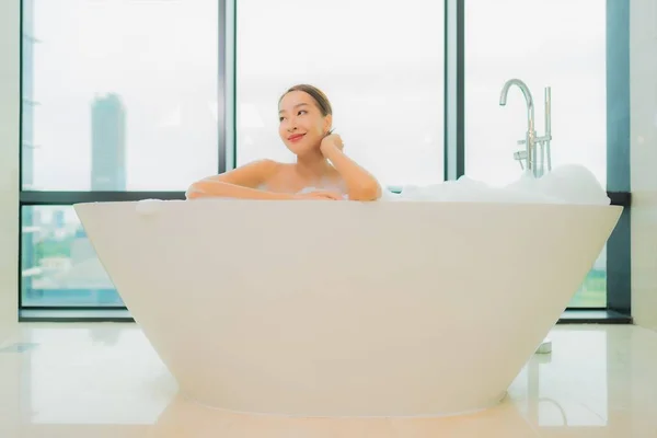 美丽动人的年轻亚洲女人在浴室的浴缸里放松微笑休闲 — 图库照片