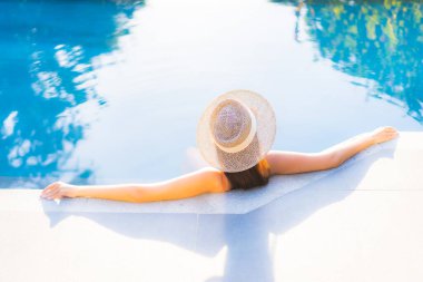 Güzel bir Asyalı kadının portresi tatil için yüzme havuzunda rahatlıyor.