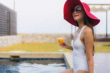 Asyalı genç bir kadının portresi mutlu bir gülümseme otel tatil beldesinde yüzme havuzunda rahatlamak