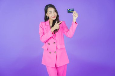 Güzel bir Asyalı kadının portresi. Renkli kredi kartıyla gülüyor.