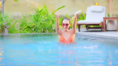 Otelde yüzme havuzunda dinlenen Asyalı güzel bir kadının görüntüsü.