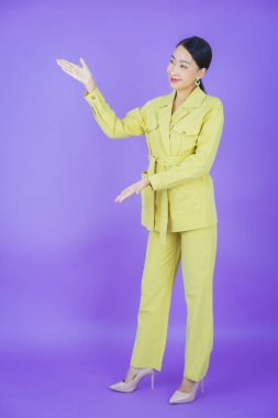 Portre güzel Asyalı kadın gülümsüyor. Renkli arka planda hareket var.