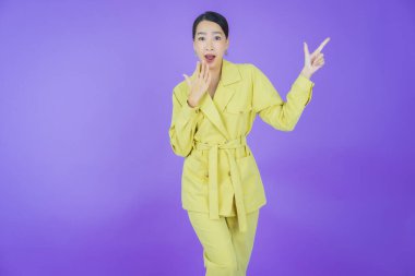 Portre güzel Asyalı kadın gülümsüyor. Renkli arka planda hareket var.