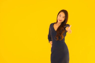 İzole edilmiş sarı arka planda hareketli güzel Asyalı kadın portresi.