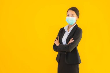 Güzel genç iş kadını portresi Korunmak için maske takıyor 19 koronavirüs sarı izole arka planda