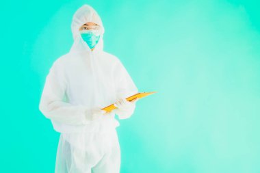 Güzel, genç Asyalı doktor kadın koronavirüsten korunmak için ppe ya da kişisel koruyucu ekipman takıyor ya da mavi izole arka planda beyaz kartı olan 19. bölgede yaşıyor.