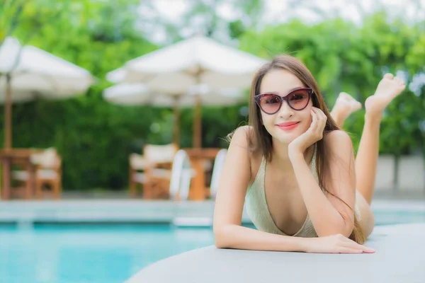 ポートレート美しい若いアジアの女性はレジャー休暇のためのホテルリゾートで屋外スイミングプールの周りの笑顔をリラックス — ストック写真