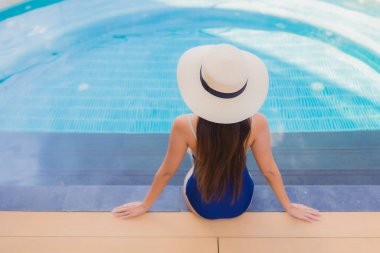 Güzel bir Asyalı kadın portresi. Rahatlayın. Yüzme havuzunda gülümseyin.