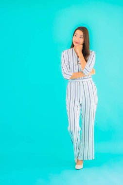 Asyalı güzel bir kadının portresi mavi izole edilmiş arka planda gülümsüyor.