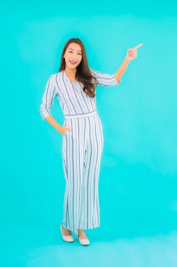 Asyalı güzel bir kadının portresi mavi izole edilmiş arka planda gülümsüyor.