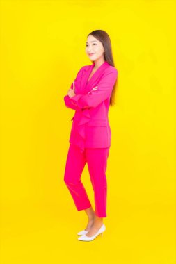 Güzel bir Asyalı kadın sarı arka planda gülümsüyor.