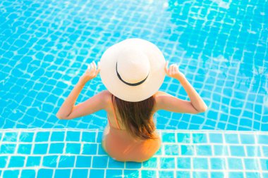 Portrait beautiful young asian woman relax smile leisure around outdoor swimming pool with sea ocean view clipart
