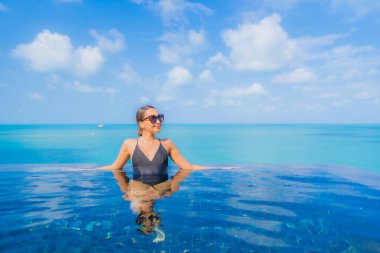 Güzel bir Asyalı kadın portresi. Rahatlayın. Okyanus manzaralı, tatil köyündeki yüzme havuzunda rahatlayın.