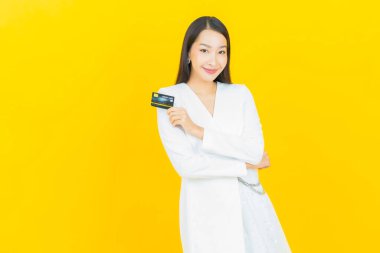 Güzel bir Asyalı kadının portresi. Renkli kredi kartıyla gülüyor.