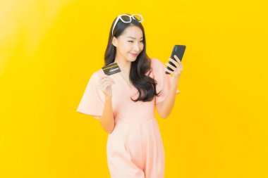 Güzel bir Asyalı kadının portresi. Renkli kredi kartıyla gülüyor.