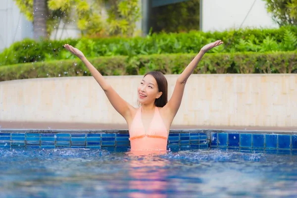 亚洲年轻貌美的女子在酒店度假胜地的室外游泳池边放松地笑着 — 图库照片